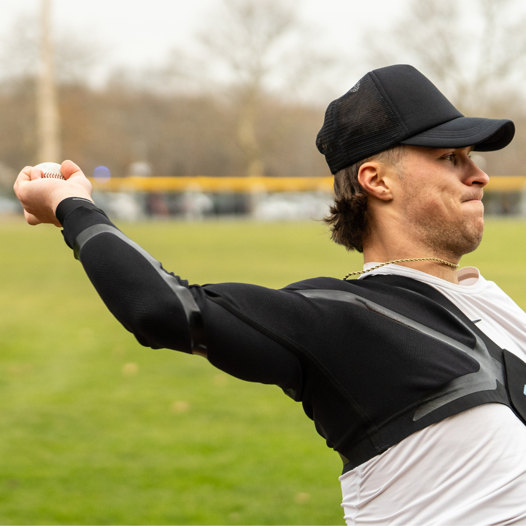Adult male using the men's Kinetic Arm shoulder and elbow support and compression sleeve for baseball.