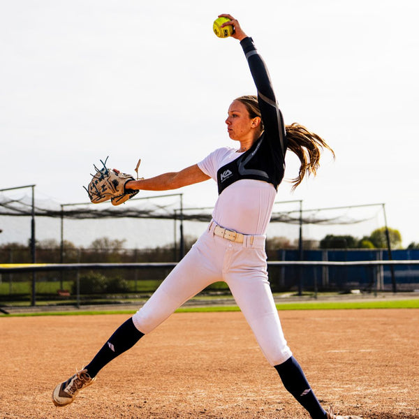 Female softball pitcher wearing the Kinetic Arm Compression and Support sleeve.